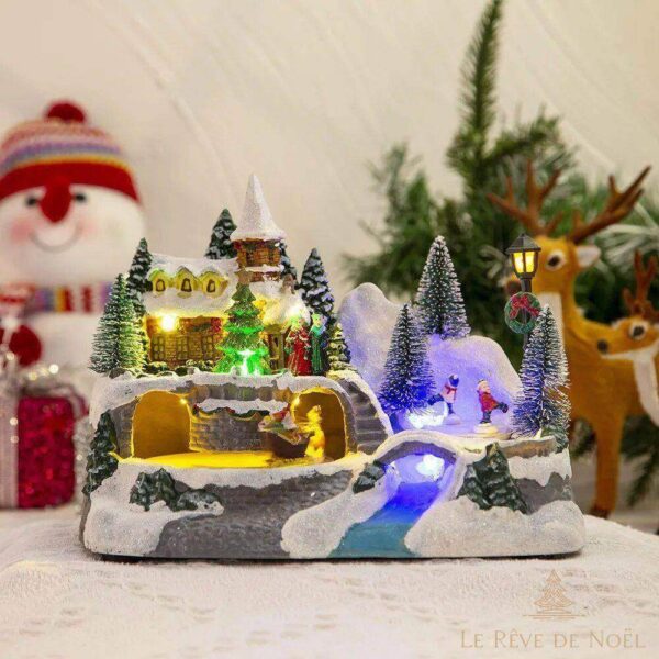 village illuminé de Noël avec neige et sapin